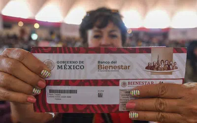 Una mujer sostiene su tarjeta del Banco de Bienestar