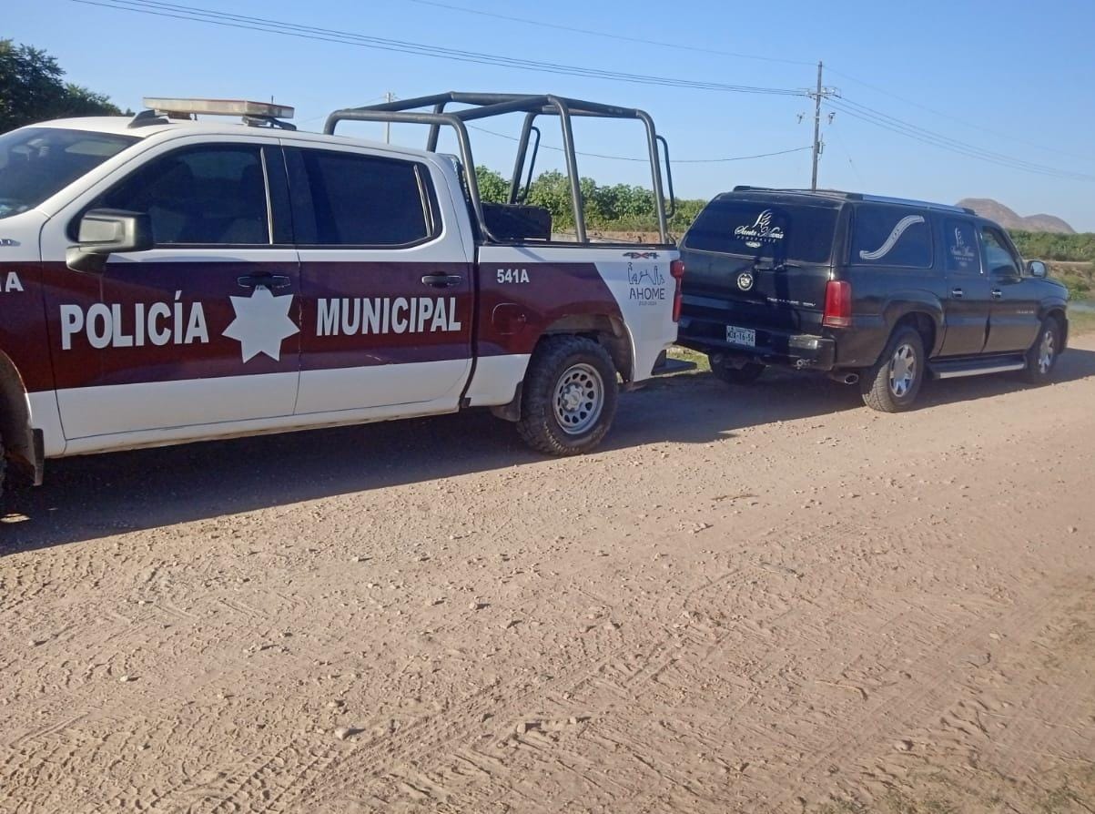 Patrulla de la Policía Municipal y un vehículo de una funeraria en el lugar del hallazgo del adulto mayor.