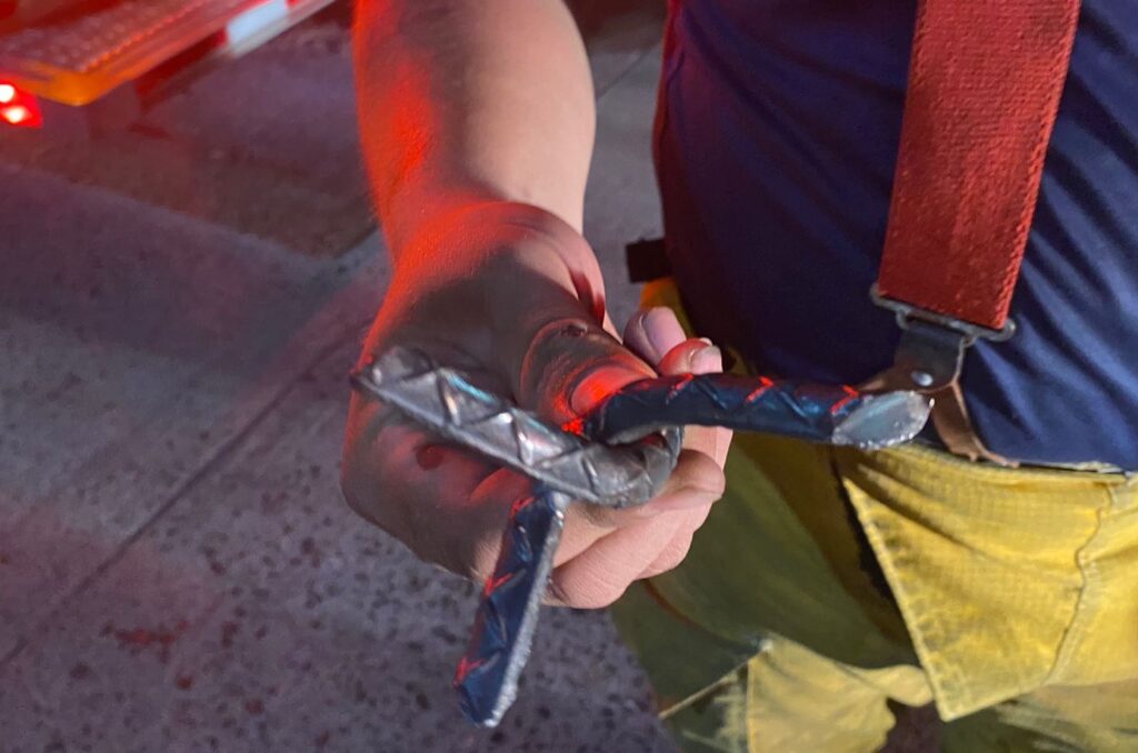 Un bombero muestra el ponchallanta por el que fue afectado su camión