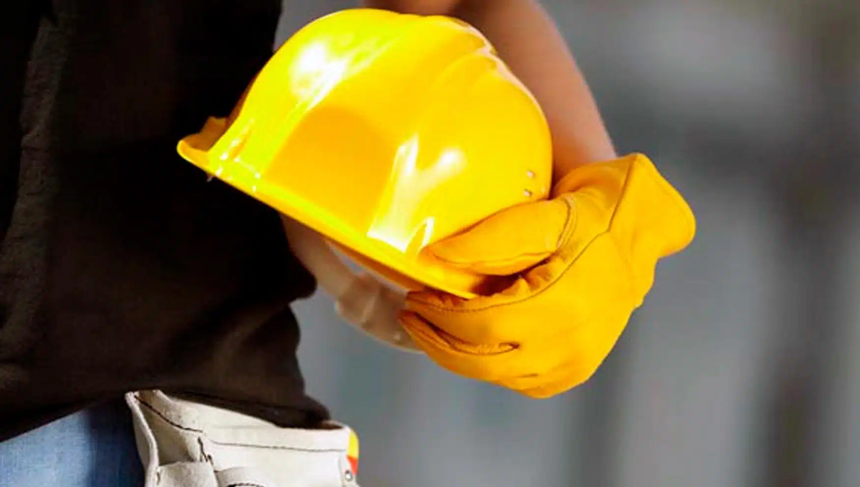 Trabajador sosteniendo un casco de seguridad.