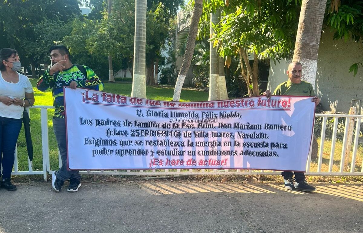 Padres de familia sostienen pancarta en protesta por falla eléctrica en escuela