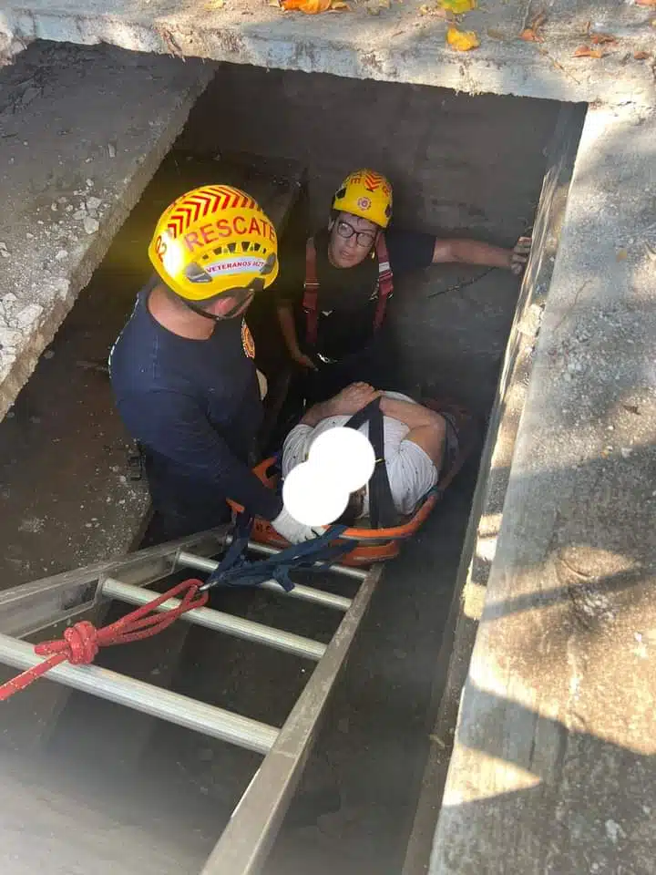 Bomberos sacando al adulto lesionado tras su caída.