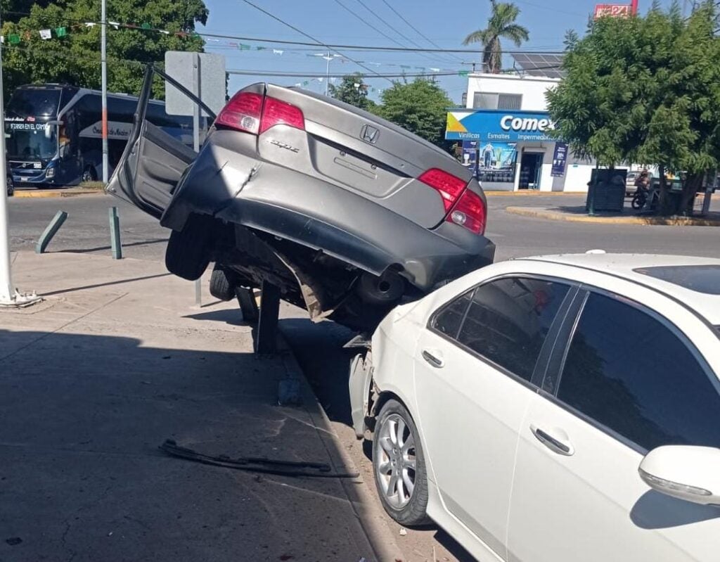 Choque de reversa provocó que el carro terminara encaramado sobre el otro.