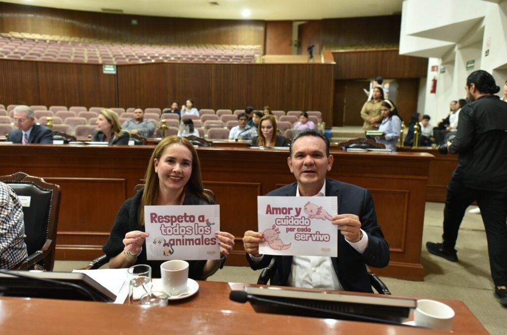 Diputados elevando cartelones en apoyo a la protección animal.