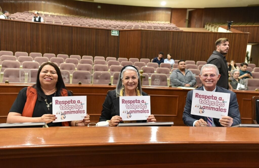 Diputados elevando cartelones en apoyo a la protección animal.