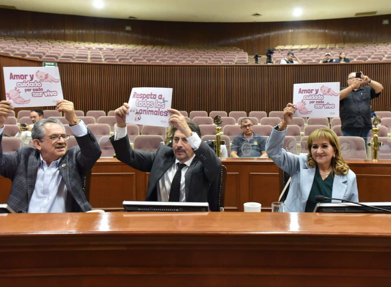 Diputados elevando cartelones en apoyo a la protección animal.