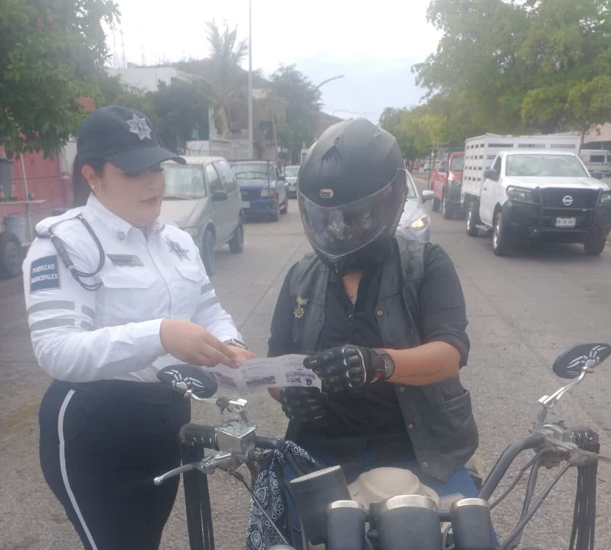 Agente vial invitando a un joven al Curso Permanente de Manejo Preventivo para Motociclistas.