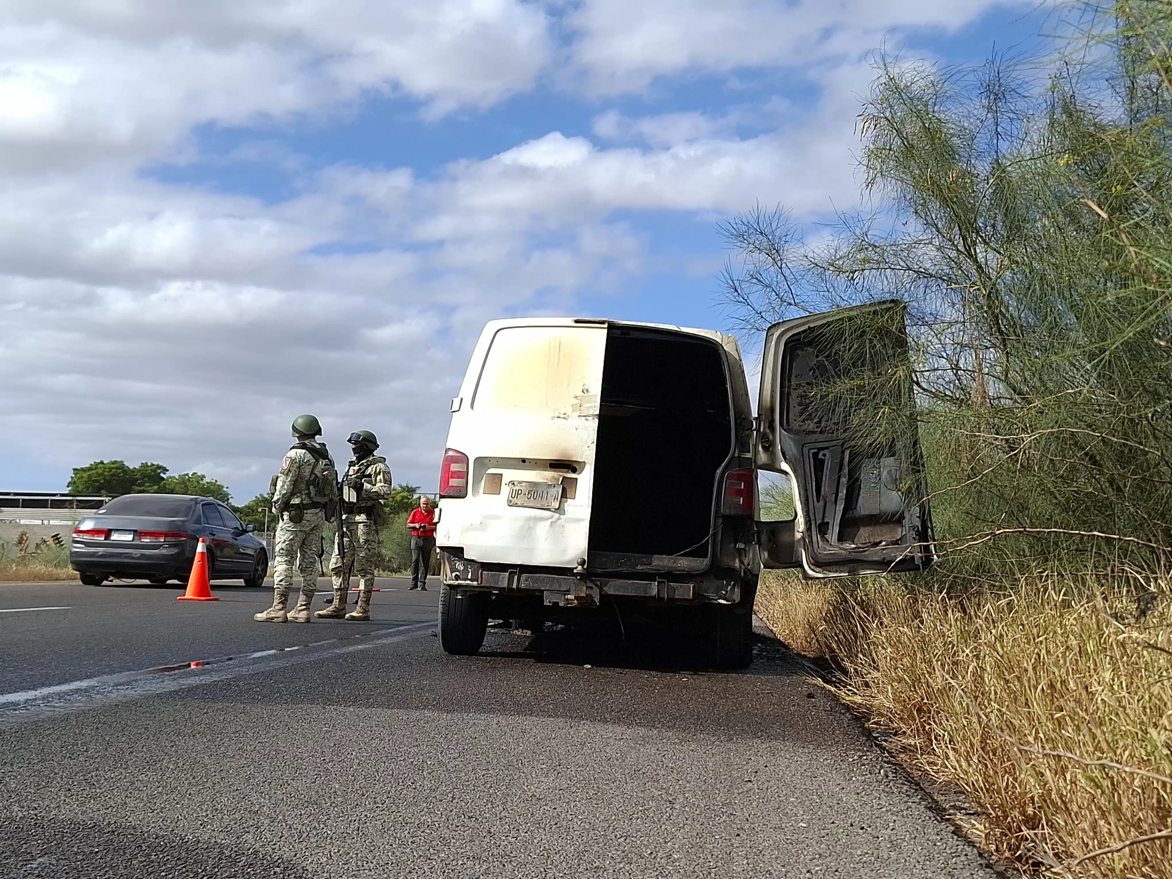 Autoridades de seguridad presentes junto a la camioneta que se incendió.