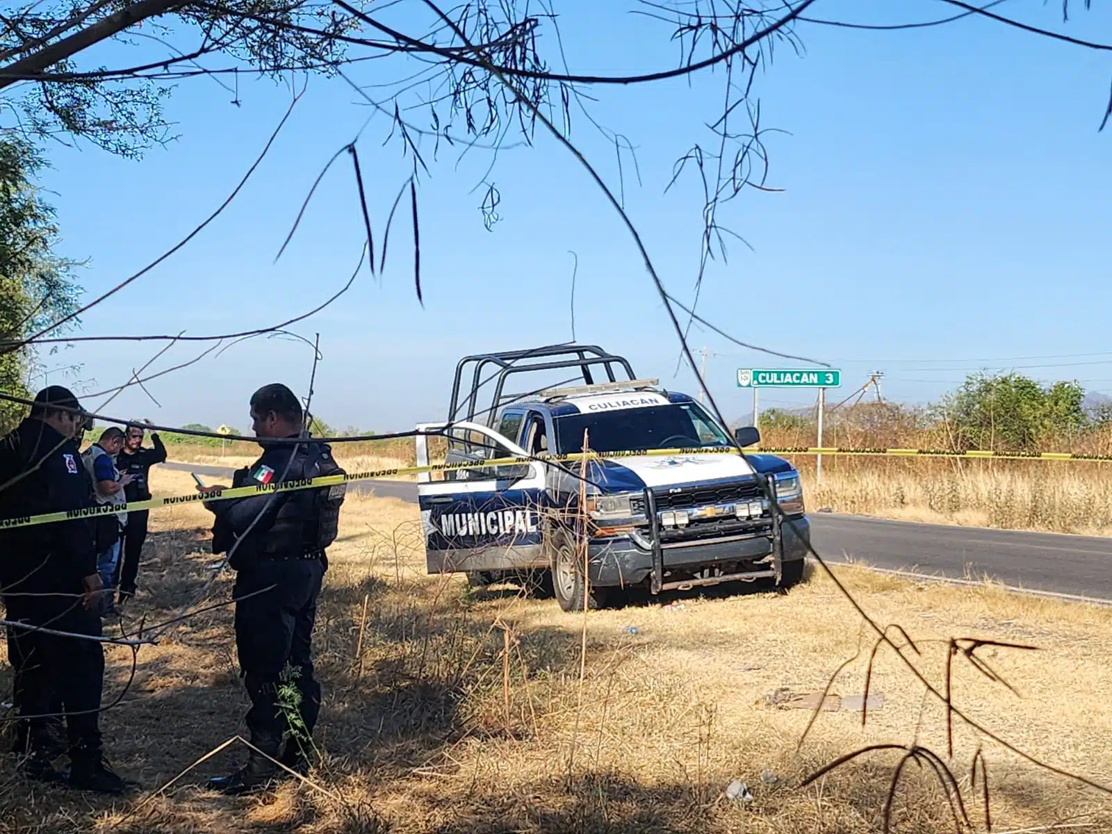 Policía Municipal junto a la carretera Culiacán-Sanalona, donde fueron encontrados los dos hombres ejecutados.