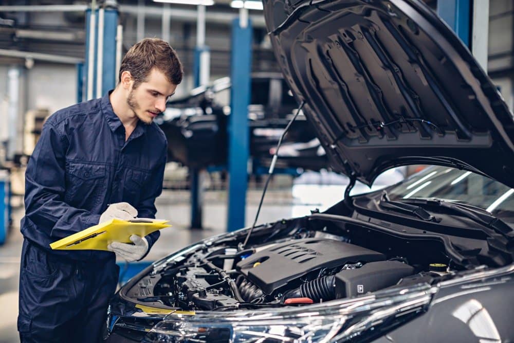 MECANICO REVISANDO UN AUTO