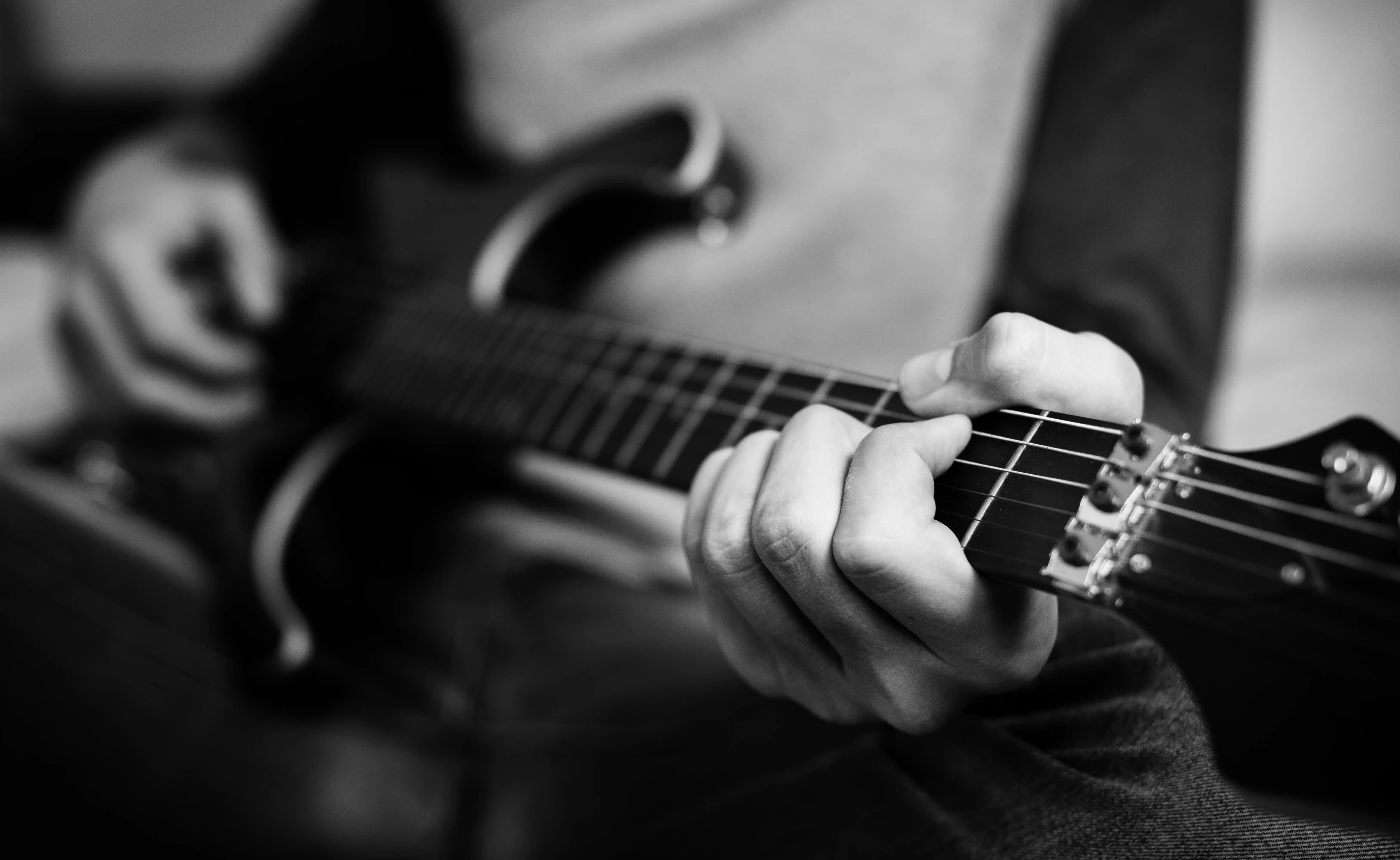 Teenage boy playing an electric guitar in a bedroom hobby and music concept