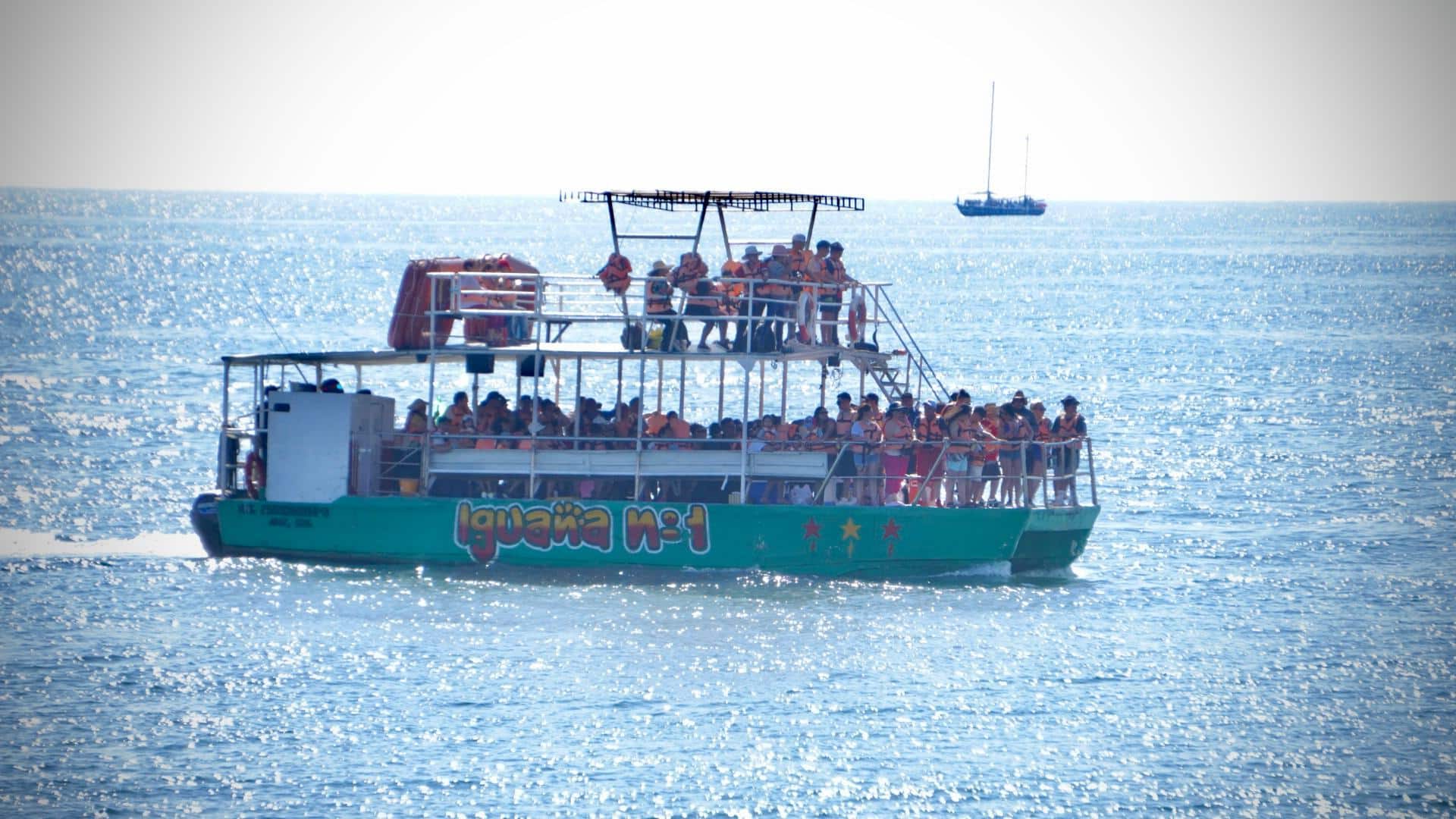 Turistas paseando por el mar en Mazatlán.