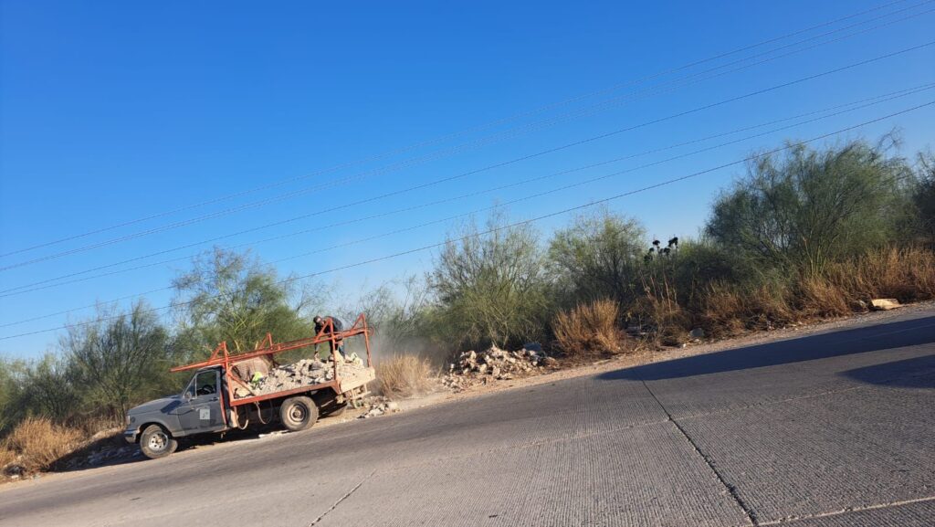 Civil tirando escombro en la orilla de la carretera Mochis-Topolobampo.