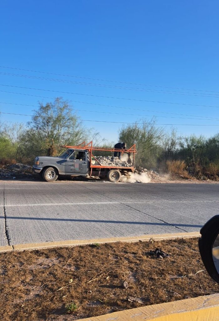 Civil tirando escombro en la orilla de la carretera Mochis-Topolobampo.