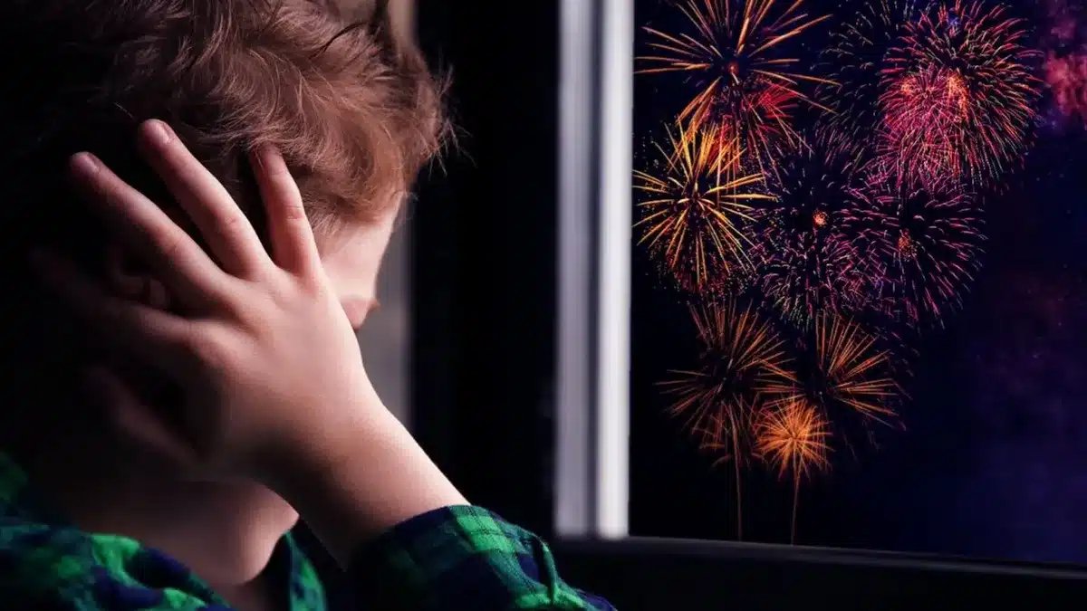 Niño cubriendo sus oídos para evitar escuchar el estruendo de la pirotecnia.