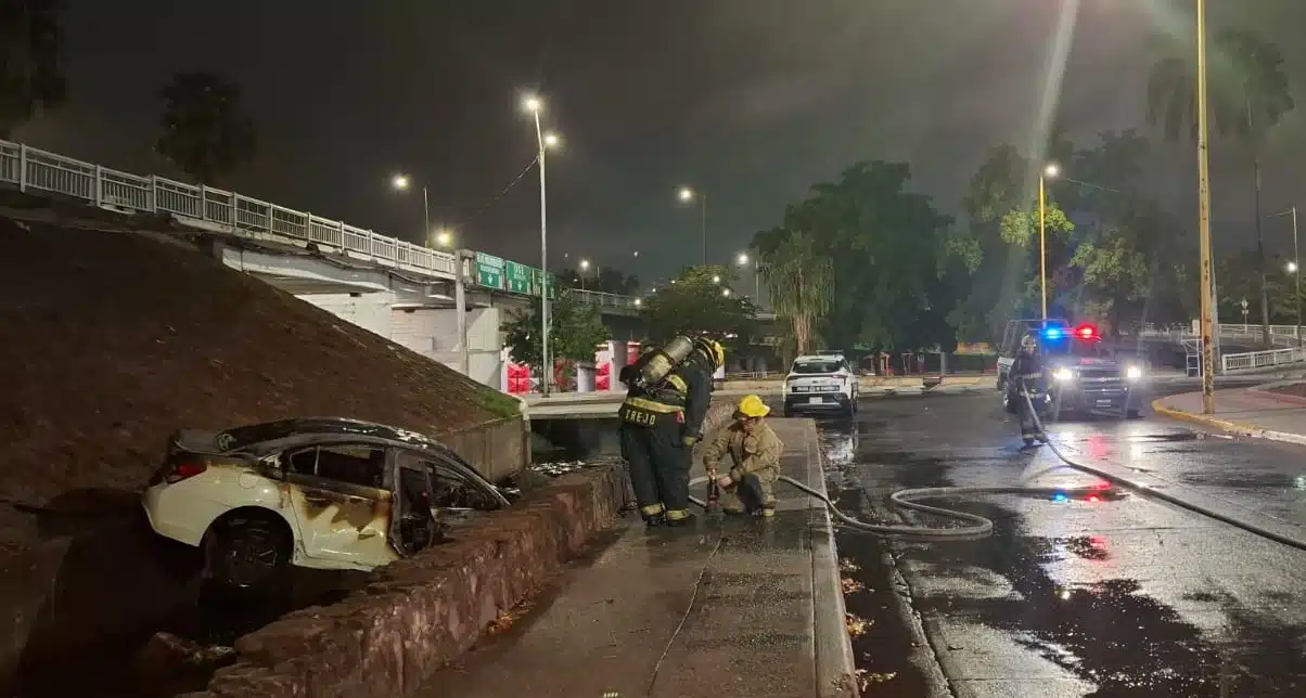 Bomberos Culiacán realizó maniobras para controlar y extinguir el fuego luego de que un automóvil perdió el control del volante y cayó de un puente