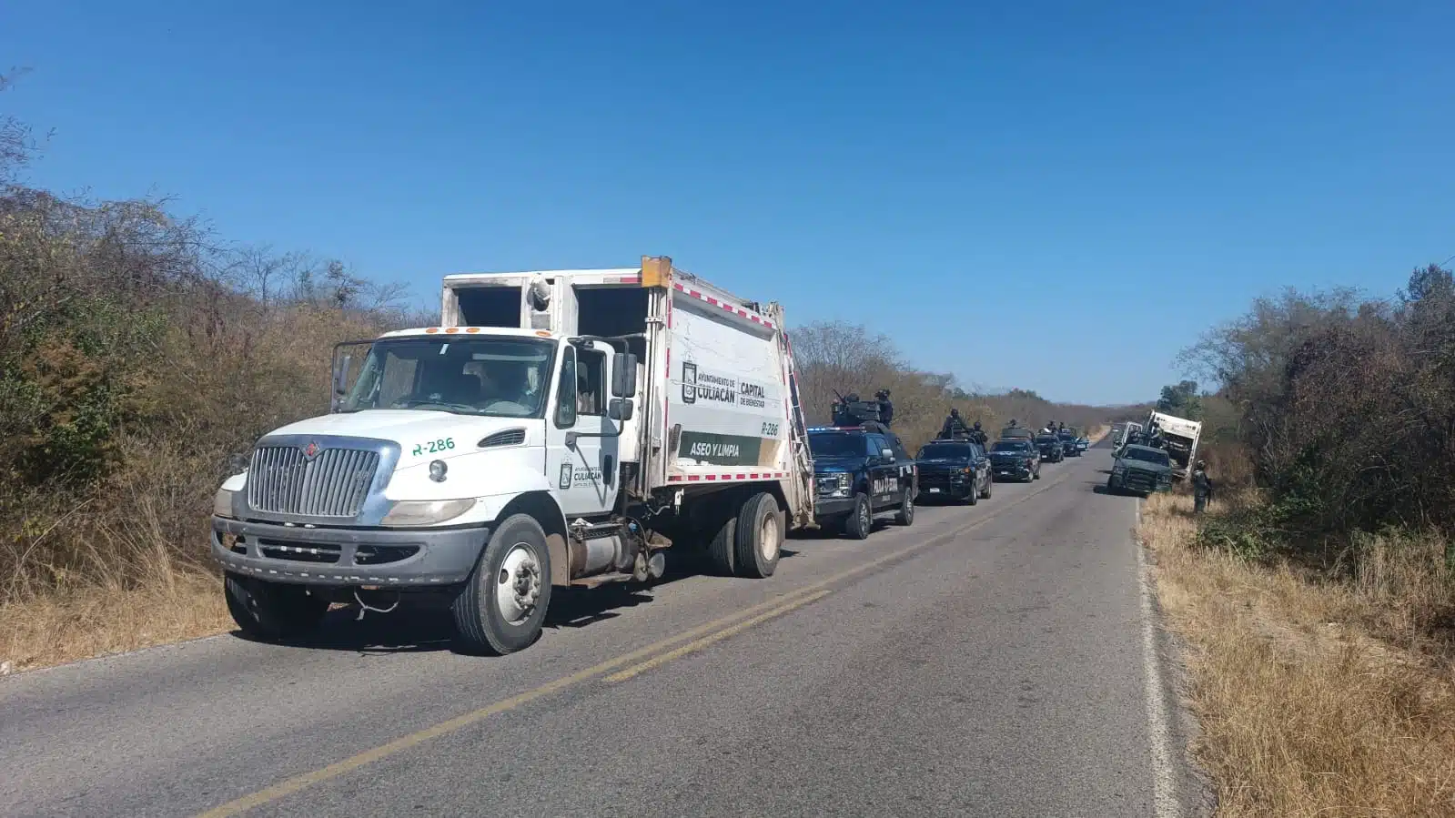 Militares y policías estatales asegurando los camiones recolectores de basura que fueron sustraídos.