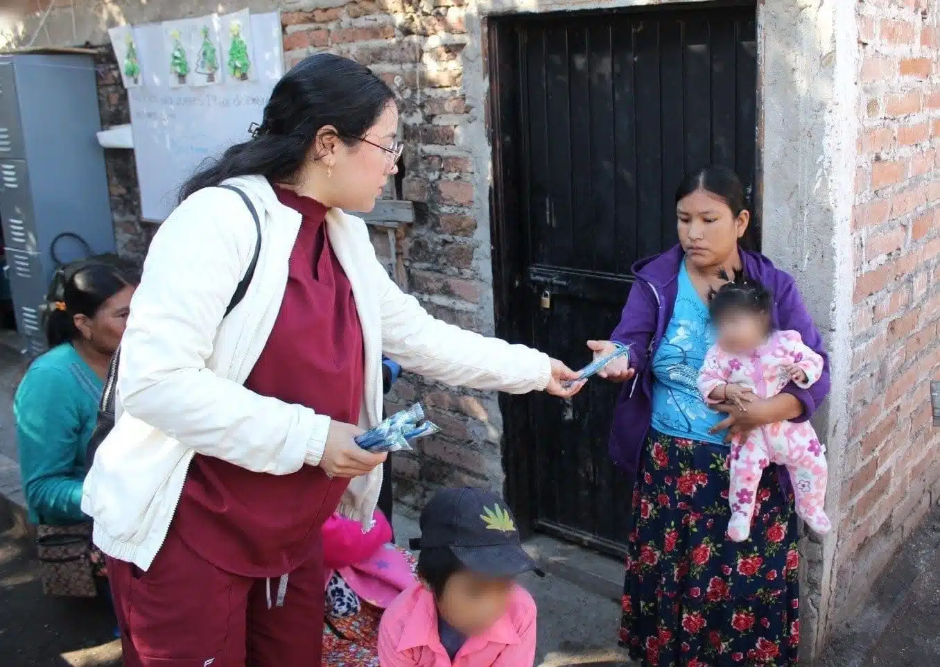 Personal de salud entregando cepillos de dientes a jornaleros agrícolas.