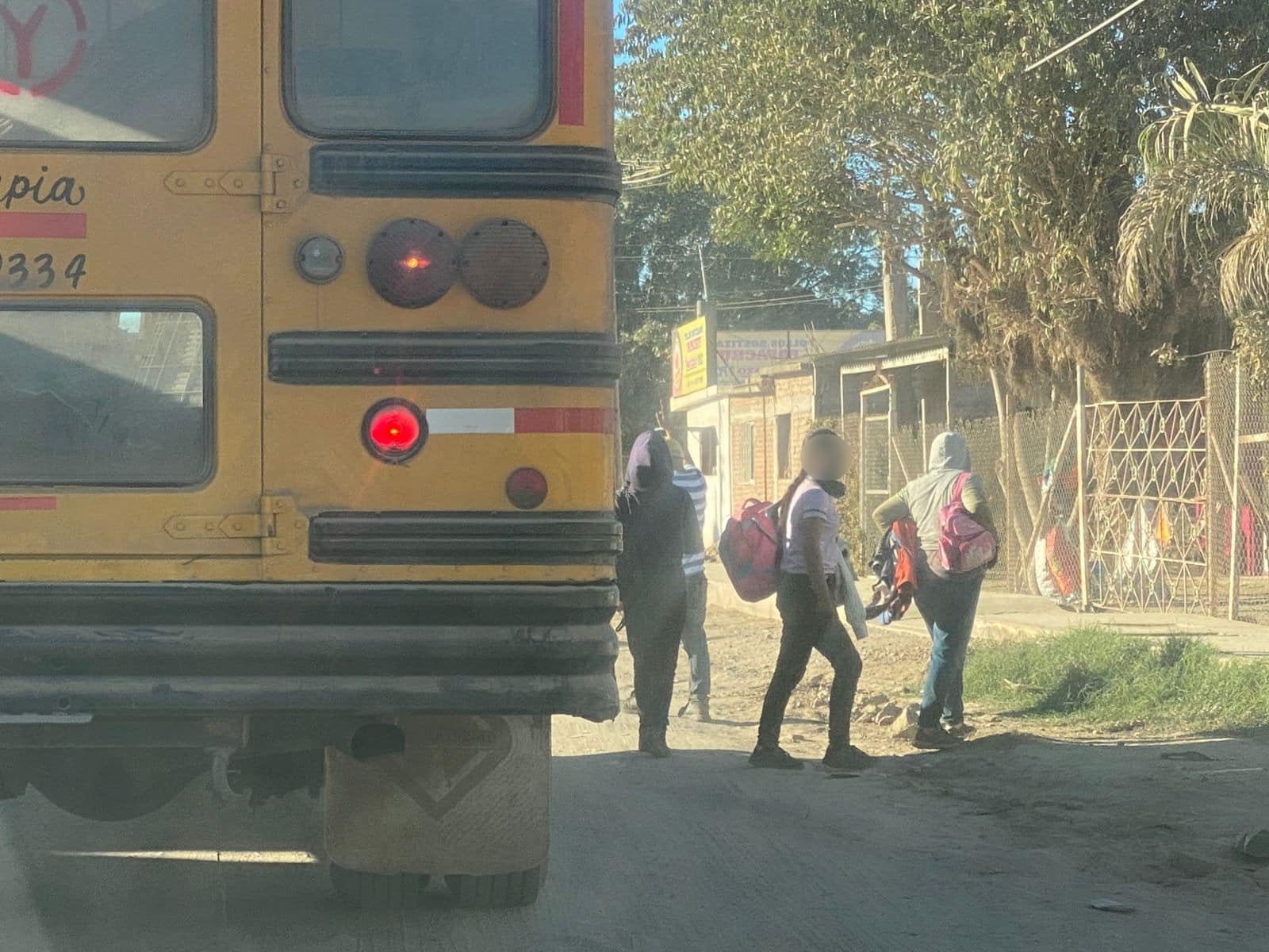 Hijos de jornaleros agrícolas bajando de un camión de transporte.
