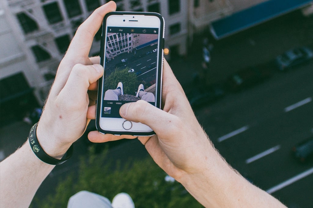 Persona sosteniendo su celular para grabar un aparente reto viral de redes sociales.