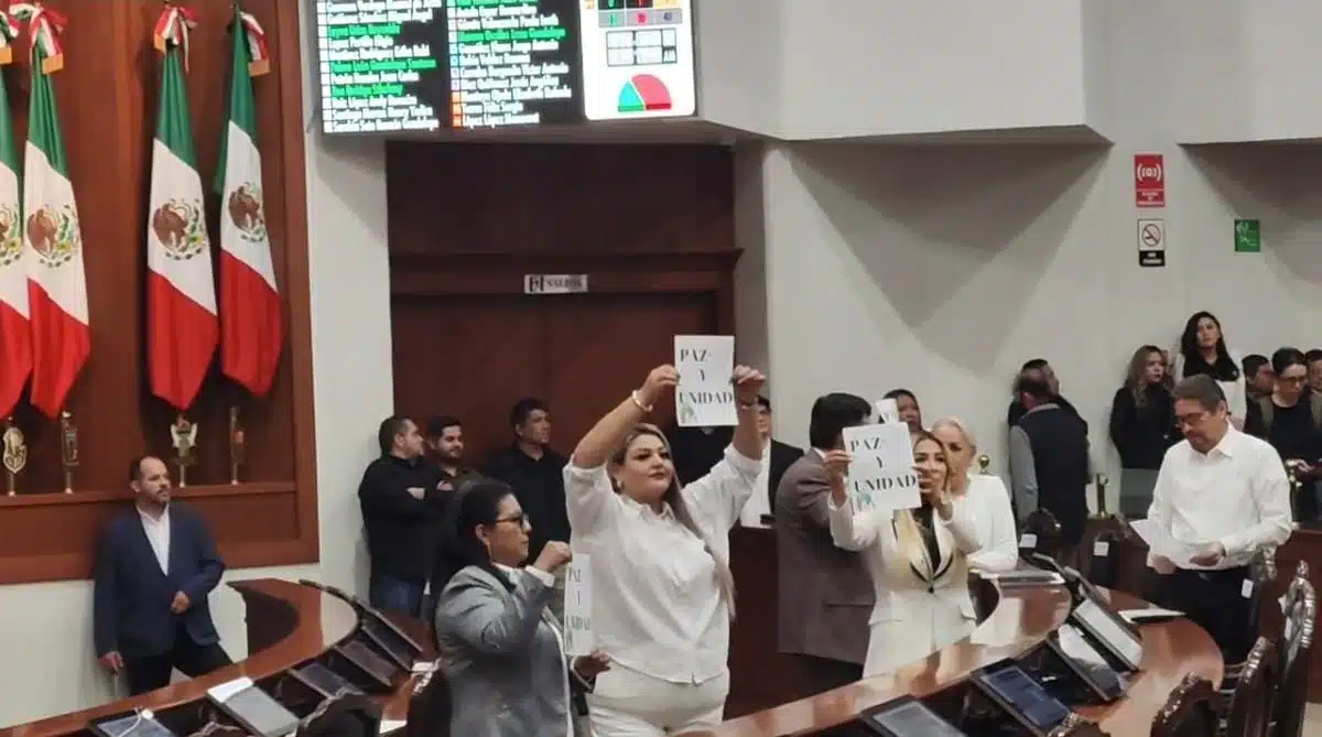 Diputados soteniendo un cartel donde piden paz y unidad