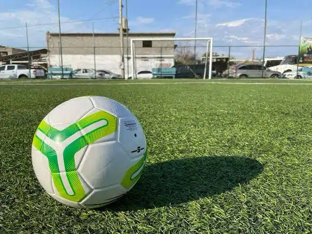 Cancha de futbol y un balón.