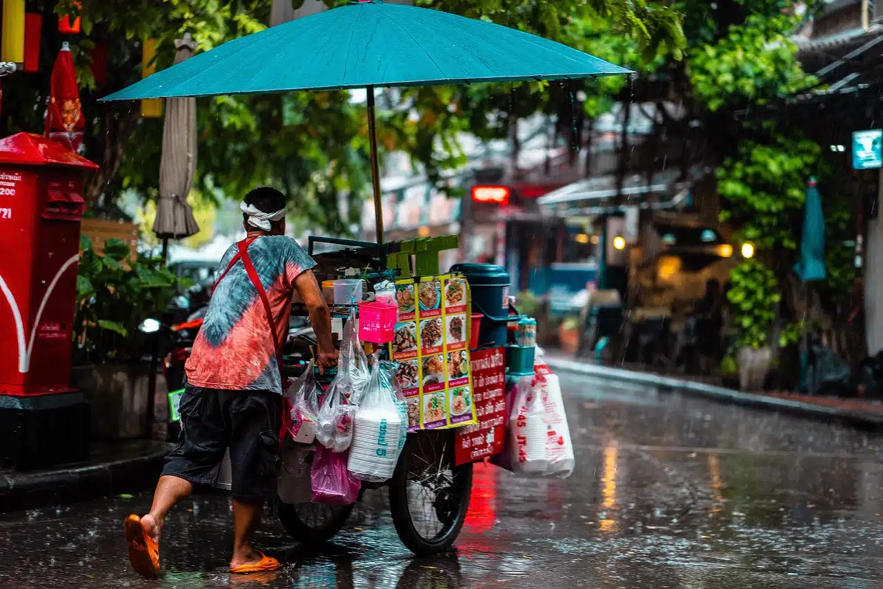 Hombre con carrito de ventas bajo la lluvia