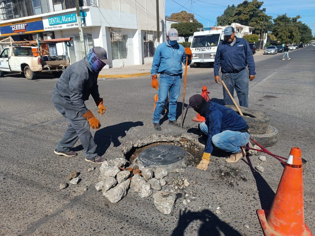 Personal de Jumapag realizando la reparación en la alcantarilla hundida.