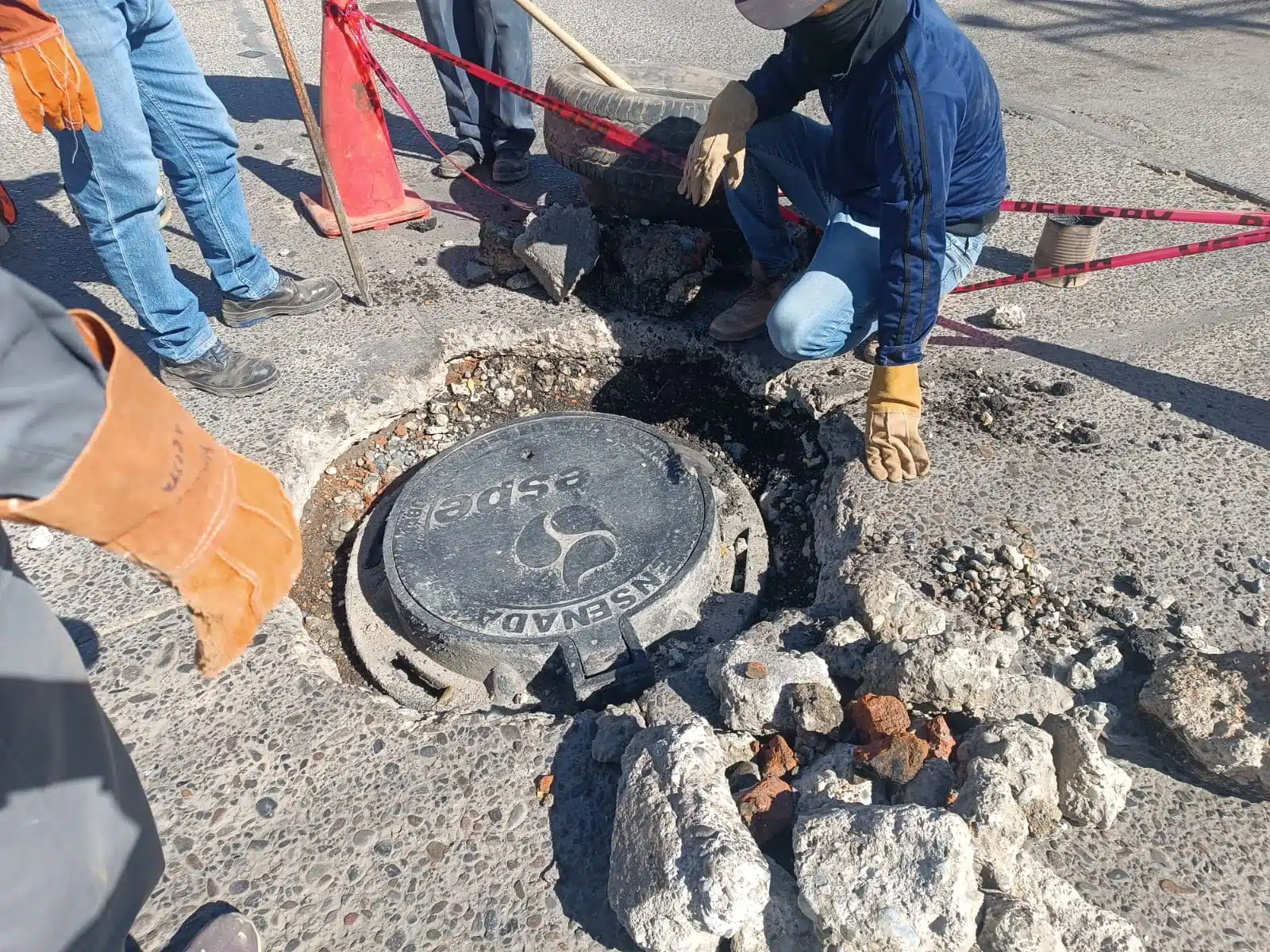 Personal de Jumapag realizando la reparación en la alcantarilla hundida.