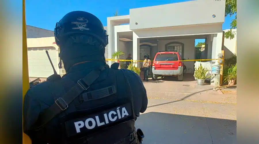 Elemento de la policía en el exterior de un domicilio