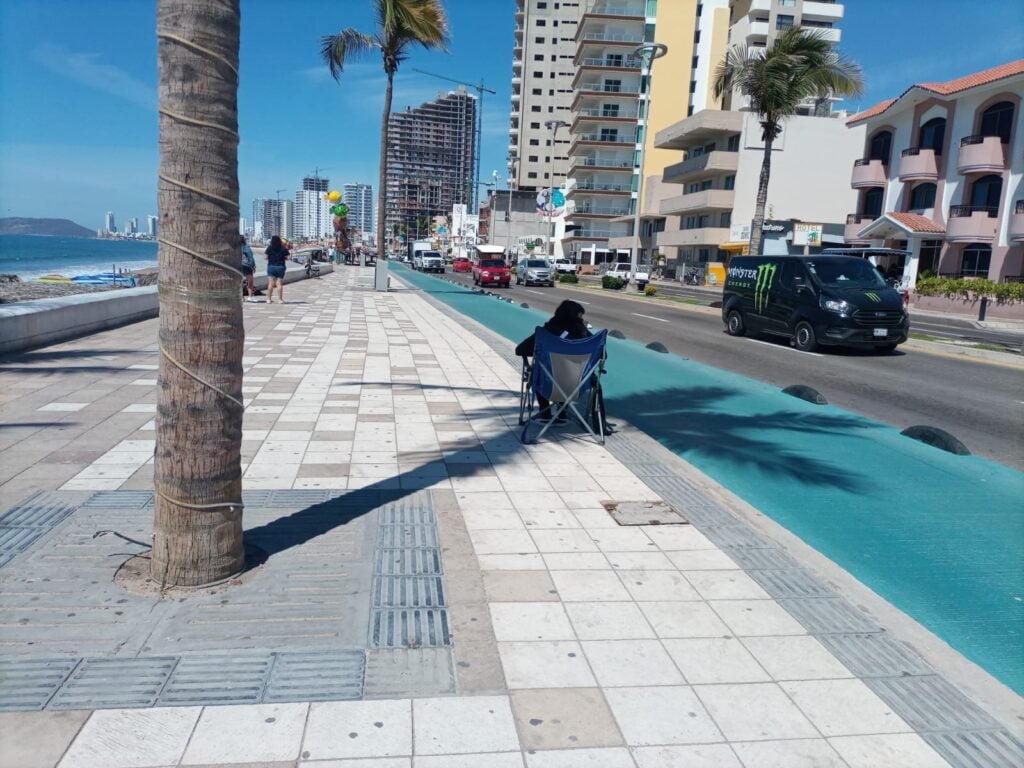 Persona apartando su lugar en el malecón para ver el desfile del Carnaval de Mazatlán.