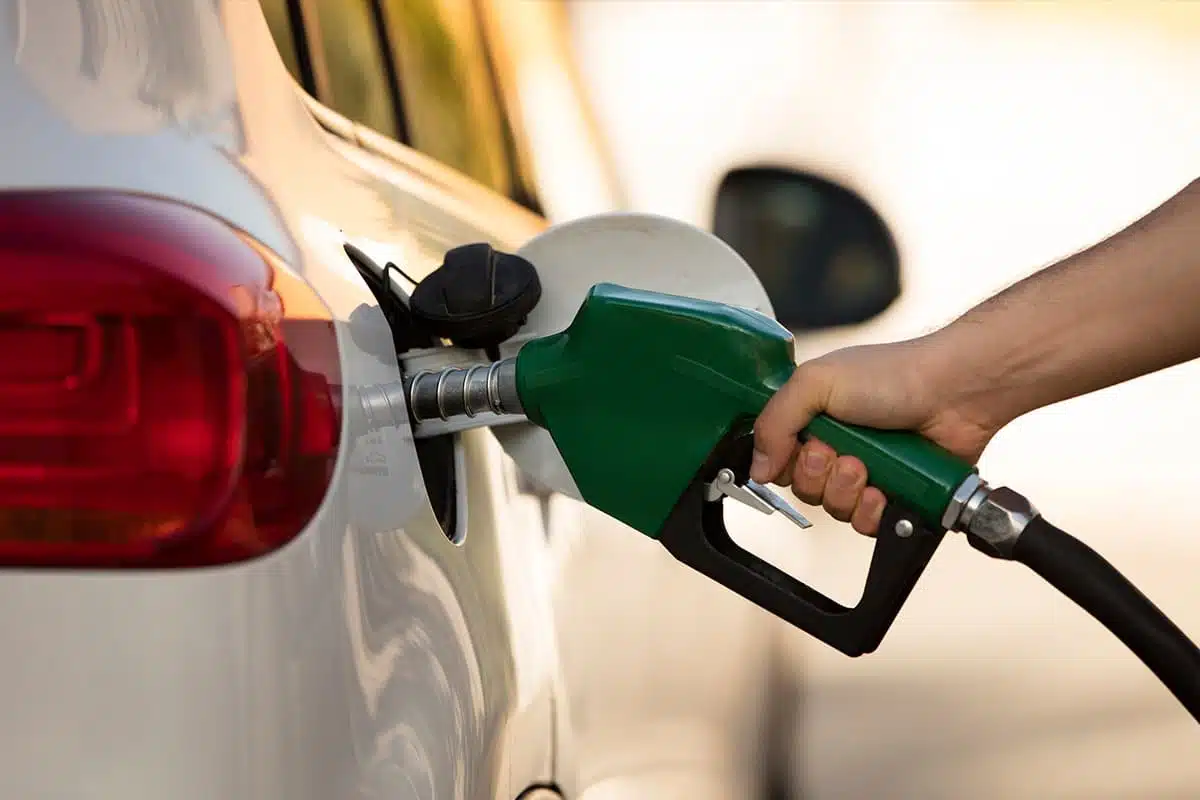 Mano con una manguera cargando gasolina en un auto