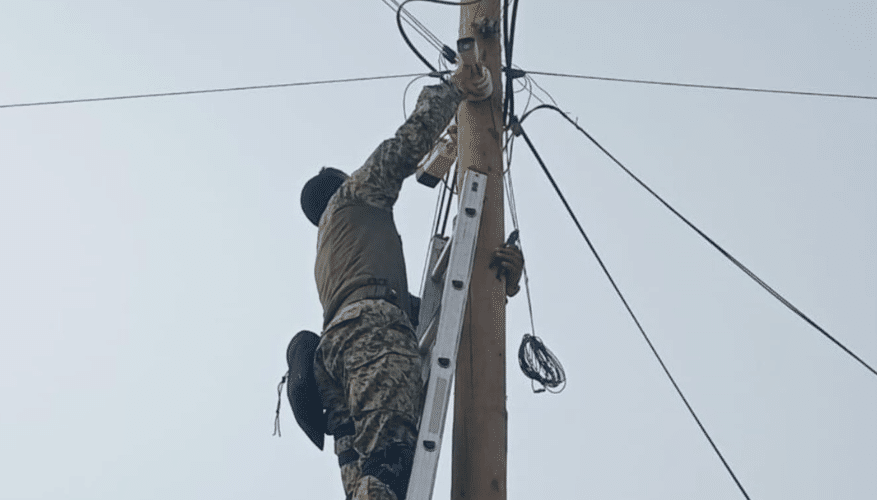 Elemento del Ejército quita una cámara de vigilancia