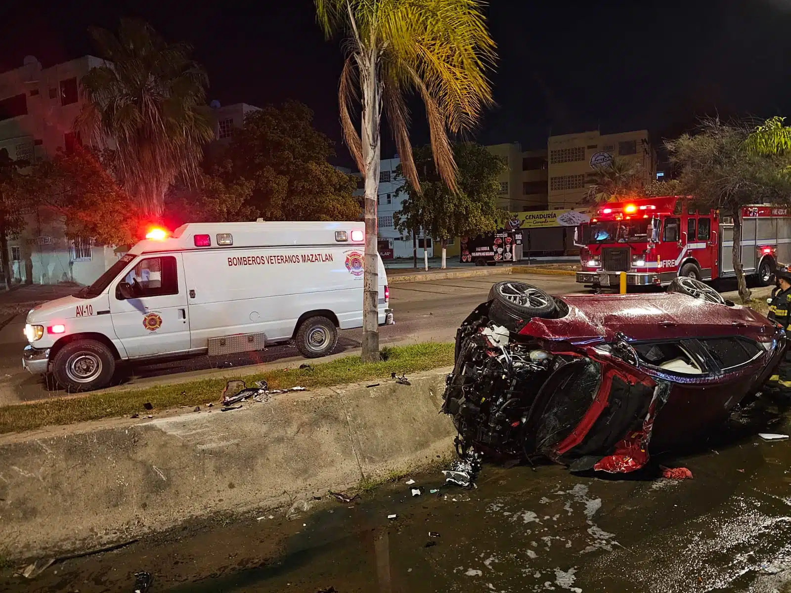 Vehículo Nissan Versa dentro de canal pluvial, tras haber volcado