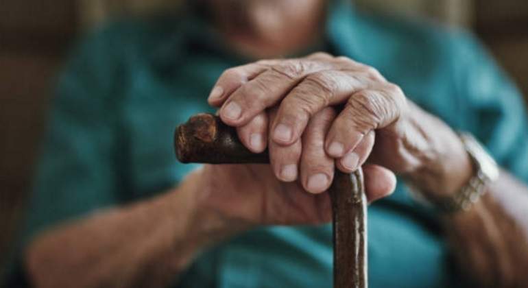 Manos de una persona mayor sobre un bastón