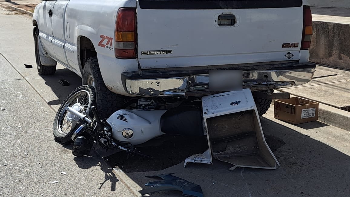 Motocicleta incrustada abajo de una camioneta tras el choque.