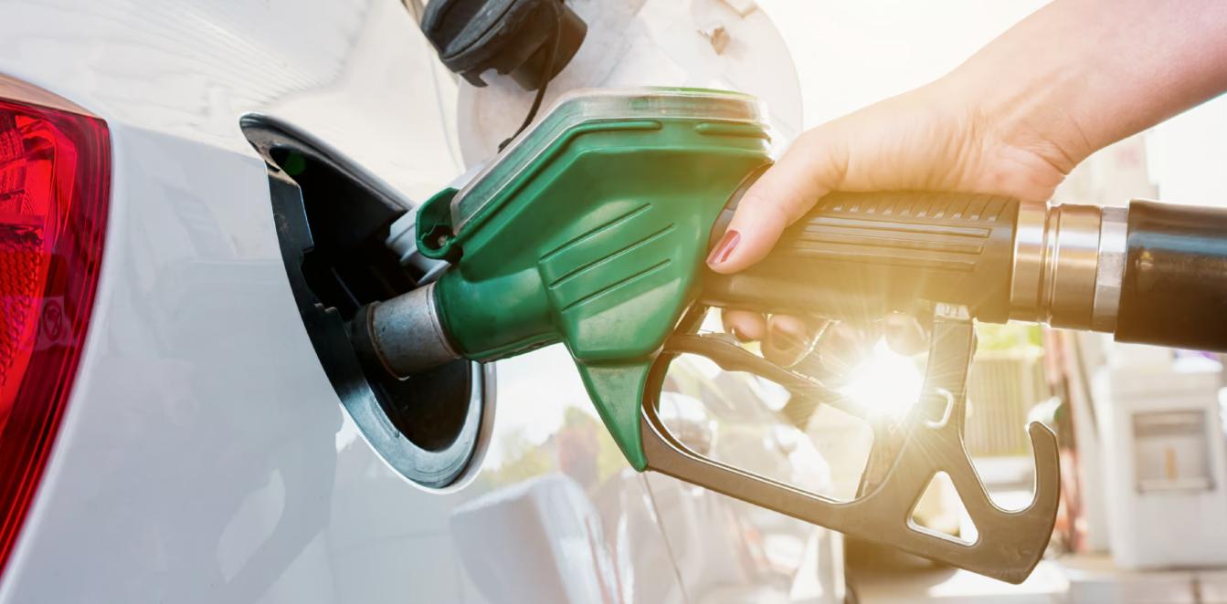MAno de una persona sosteniendo una manguera dispensadora de gasolina color verde
