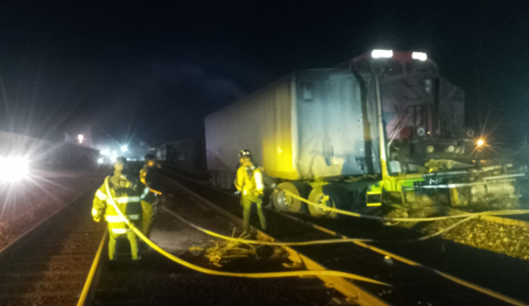 Personal de seguridad resguardan la zona donde un tren embiste un tráiler