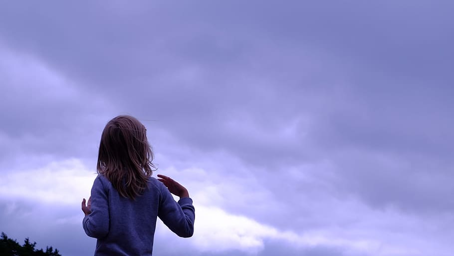 Una persona viendo el cielo nublado.