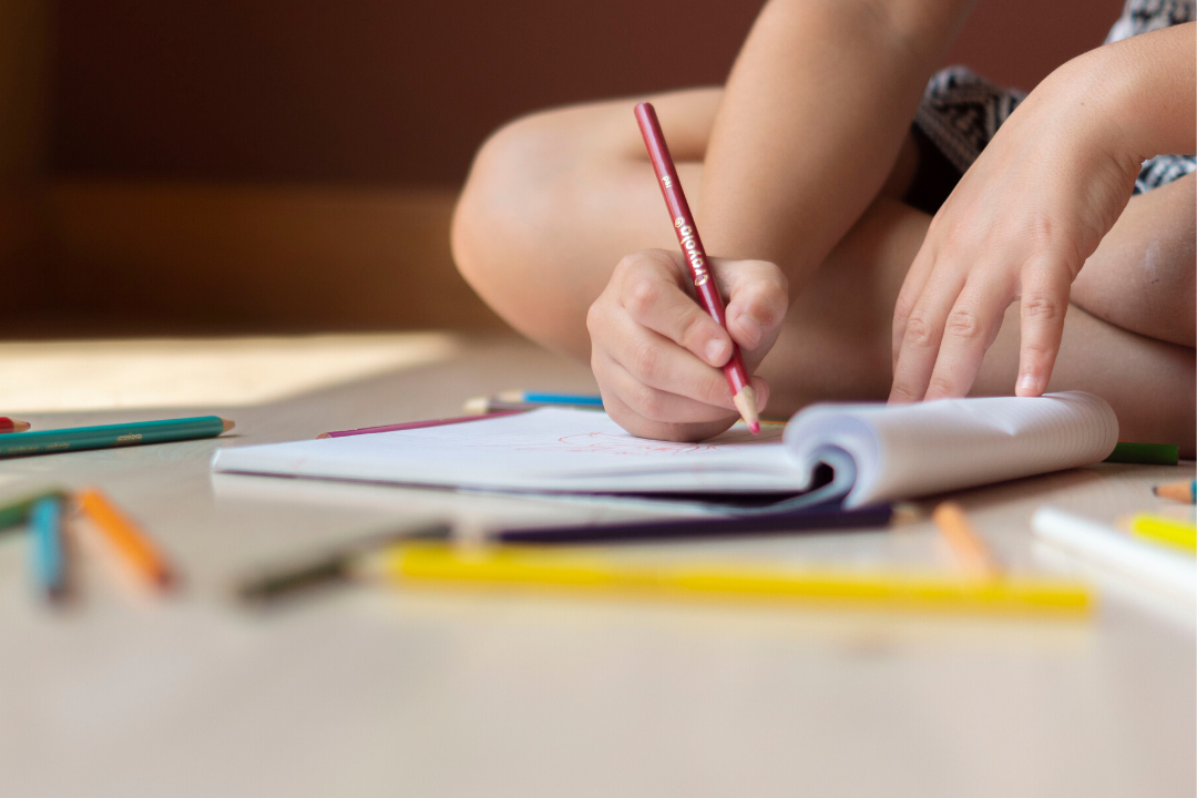 Niño coloreando en una libreta.