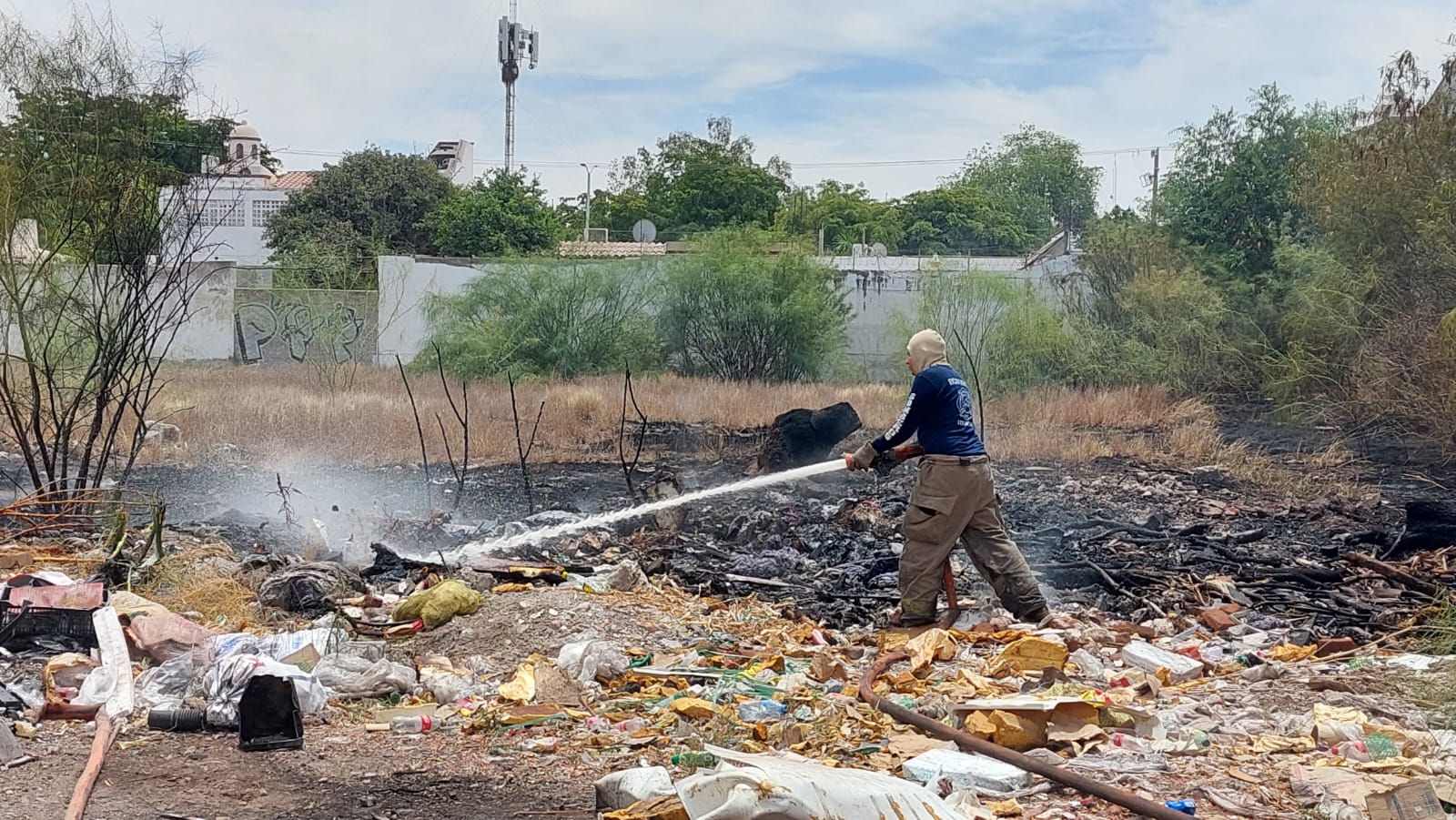 Departamento de Bomberos de Los Mochis combatiendo el incendio en un predio baldío.