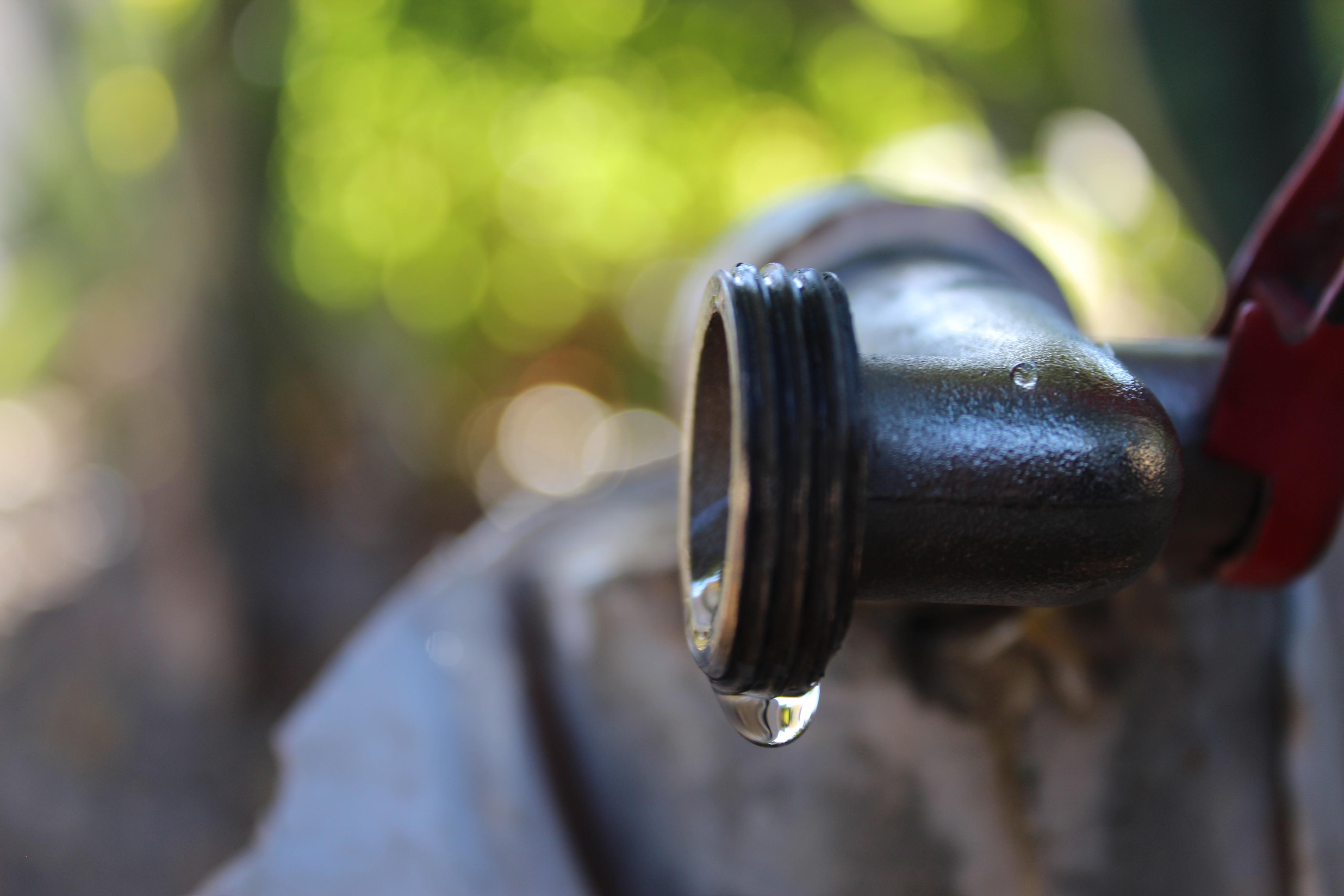 Gota de agua colgando de una llave.