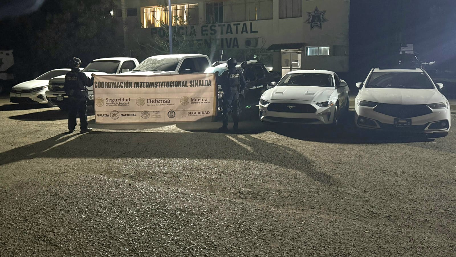Elementos de la Policía Estatal junto a los vehículos asegurados.