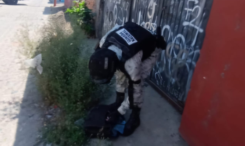 Elemento de la Guardia Nacional revisa una mochila abandonada