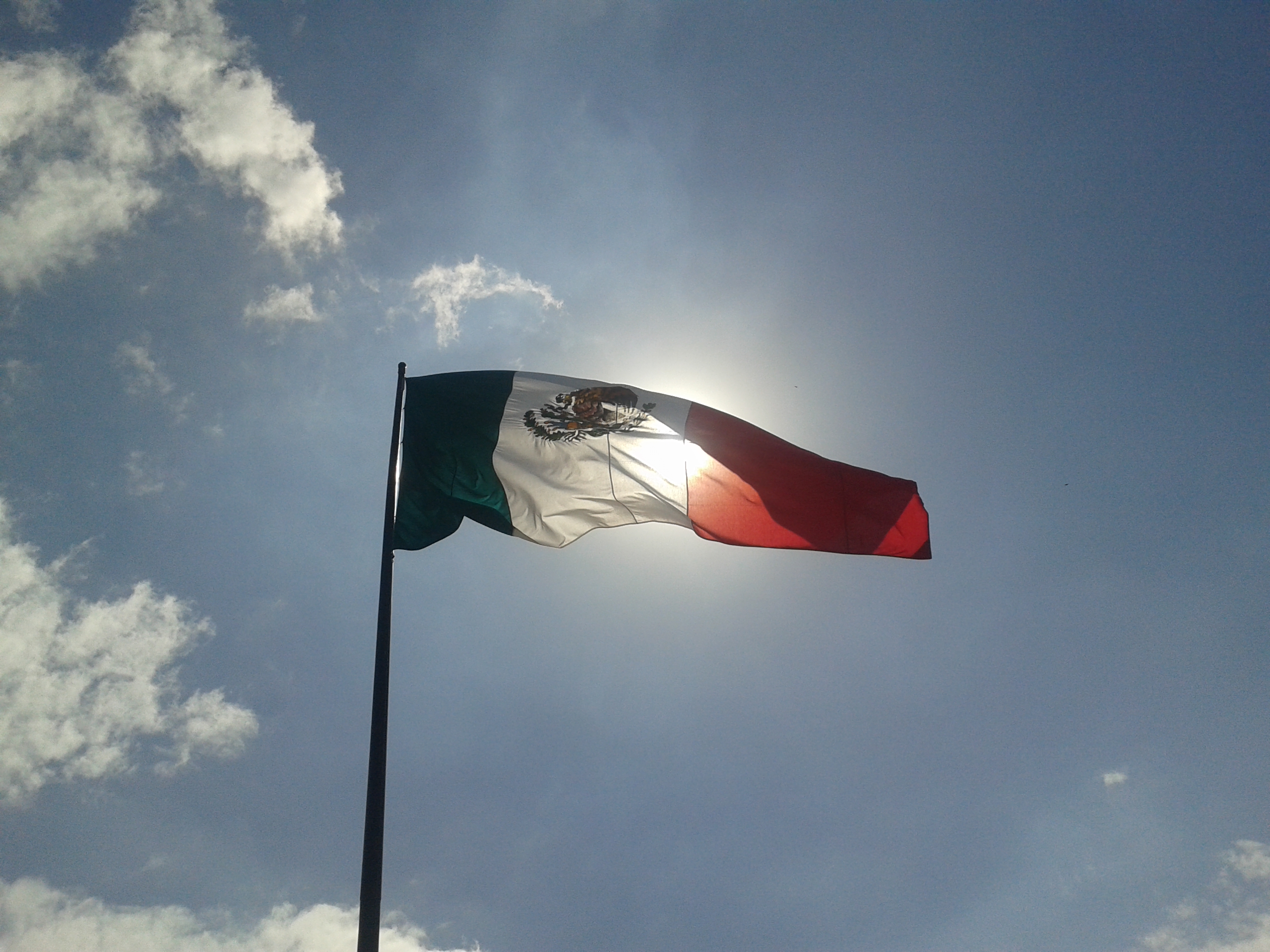 Bandera de México izada en un día soleado.