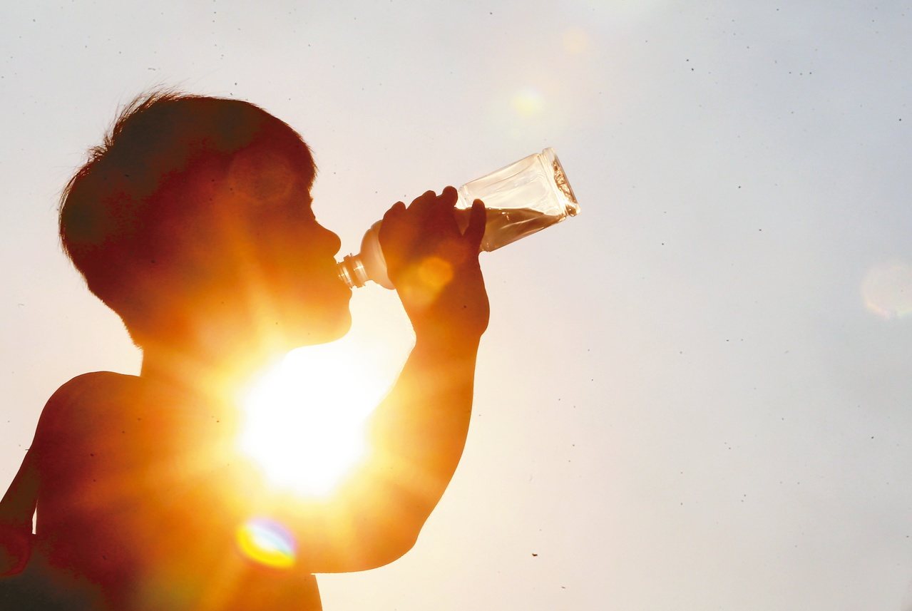 Persona bebiendo agua frente al sol.