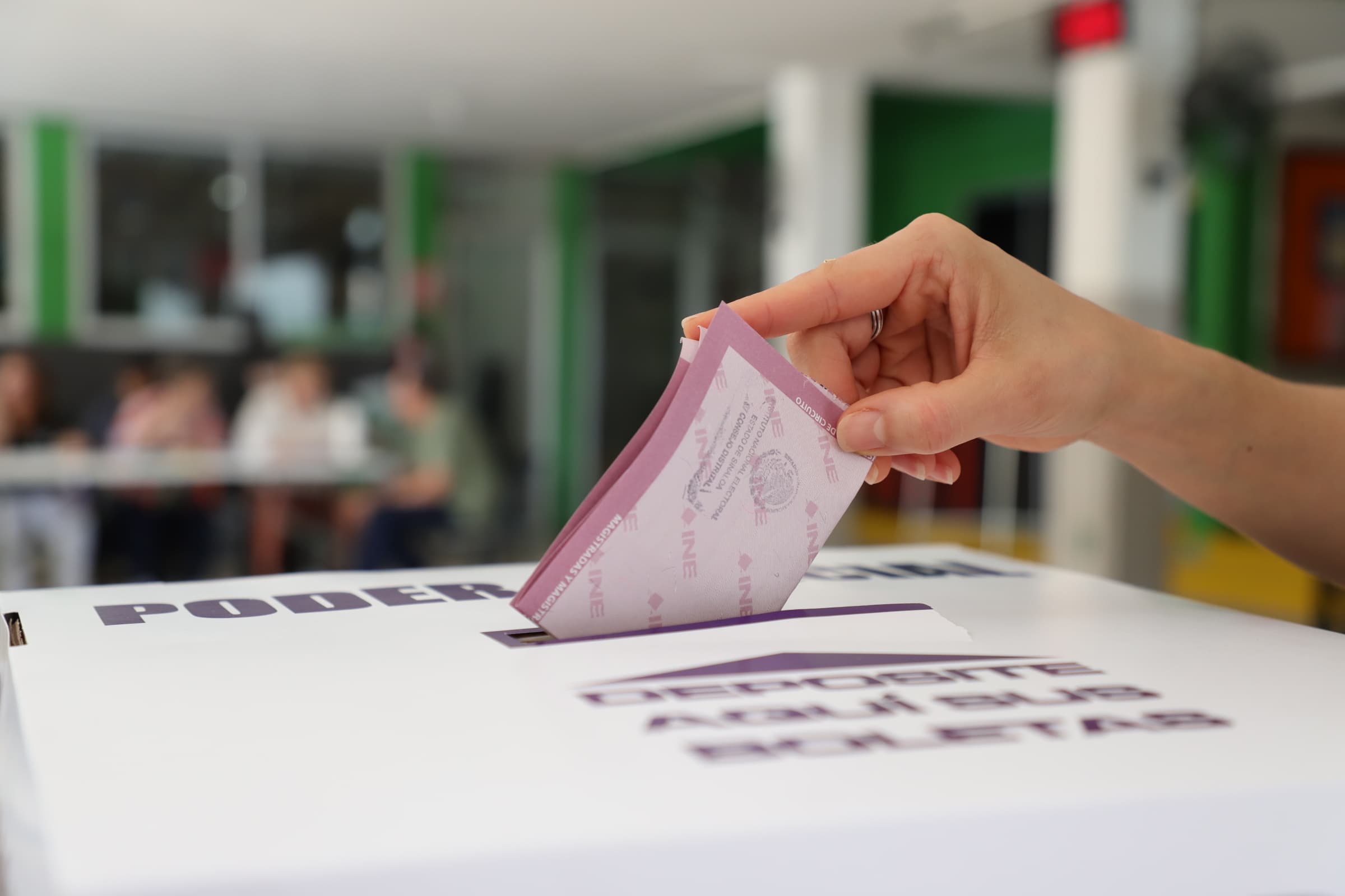 Persona introduciendo su voto en la urna.