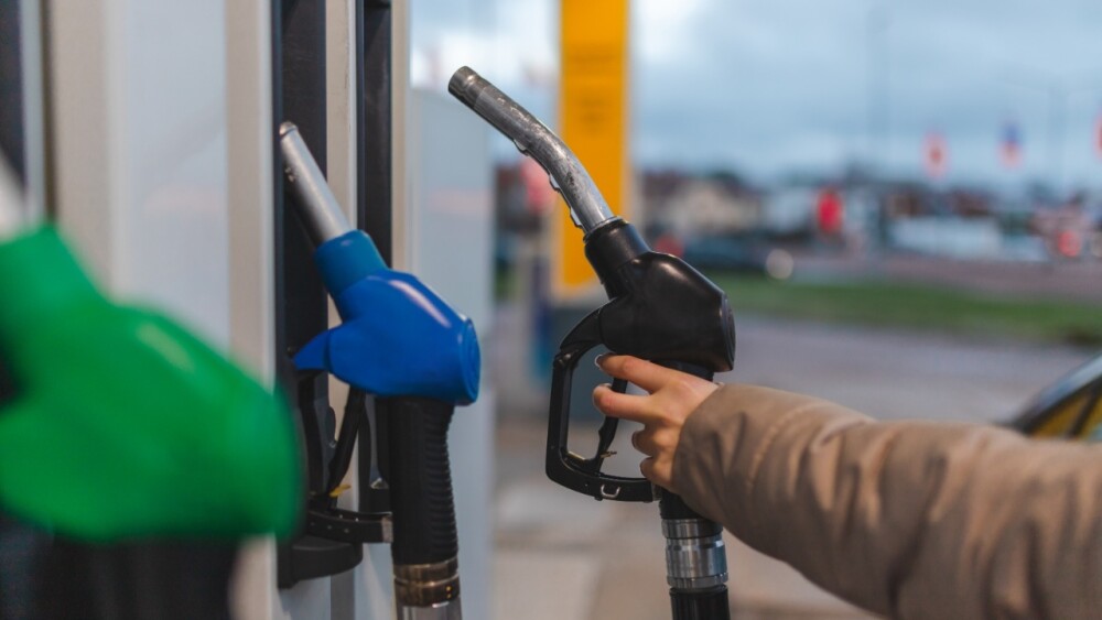 Persona sosteniendo una pistola despachadora de gasolina.