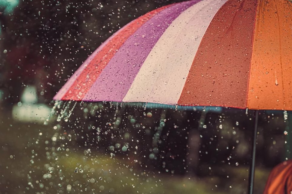 Gotas de lluvia cayendo en un paraguas.
