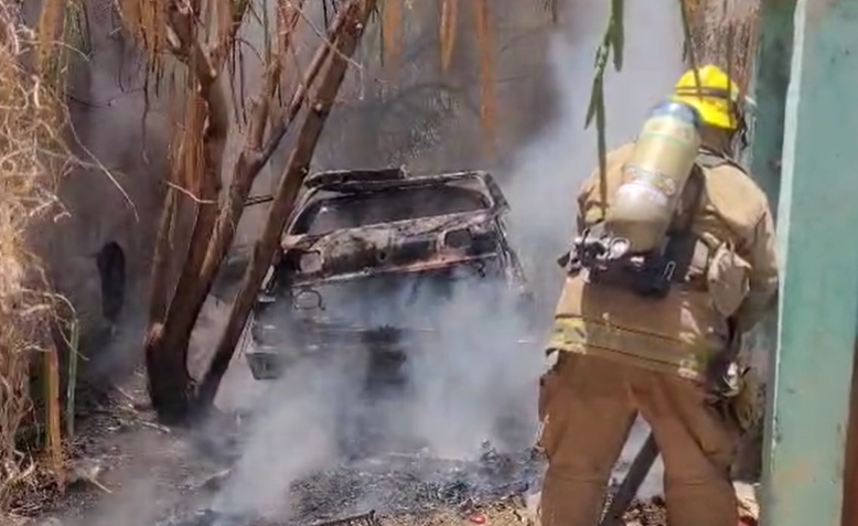 Bombero trata de apagar incendio sobre un vehículo